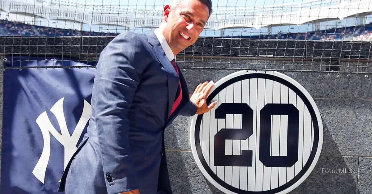 Jorge Posada posando al lado de su número retirado en New York