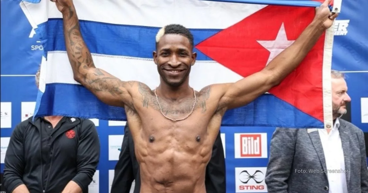 William Scull sonriendo con una bandera cubana entre sus manos