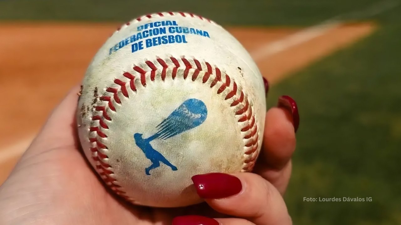 La abogada Lourdes Dávalos sosteniendo una pelota oficial de la Federación Cubana de Beisbol