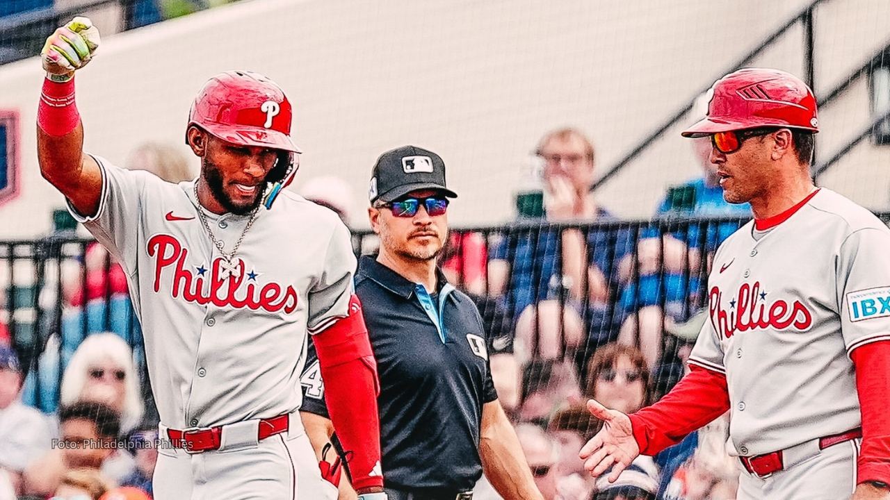 Johan Rojas celebrando un batazo con el coach de Philadelphia Phillies